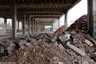 Atelier du bâtiment principal : série de poteaux poutres en béton et amas de débris, usine TASE - 11